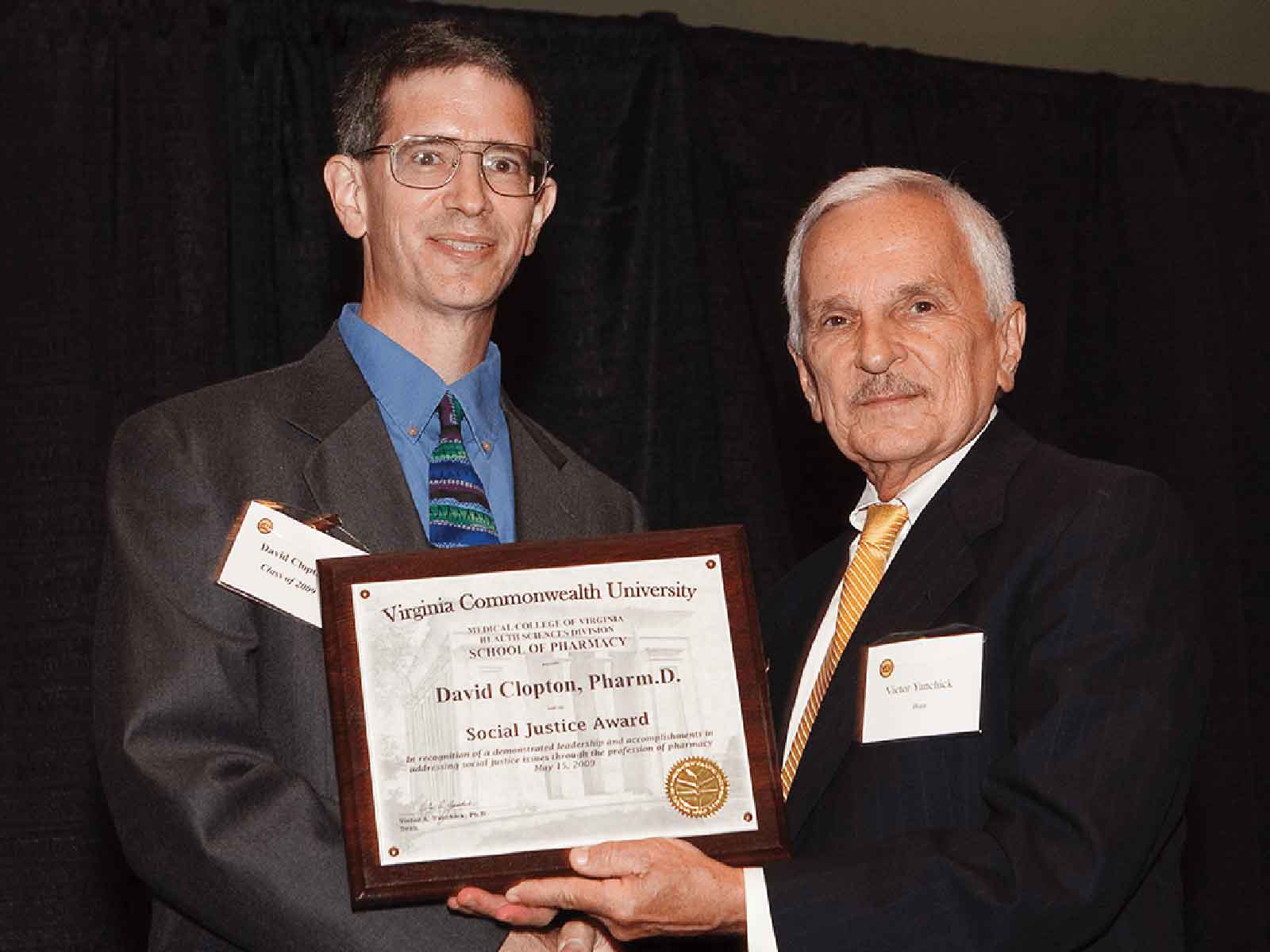 David Clopton, Ph.D., Pharm.D., receiving the Social Justice Award in 2009 from former School of Pharmacy Dean Victor Yanchick