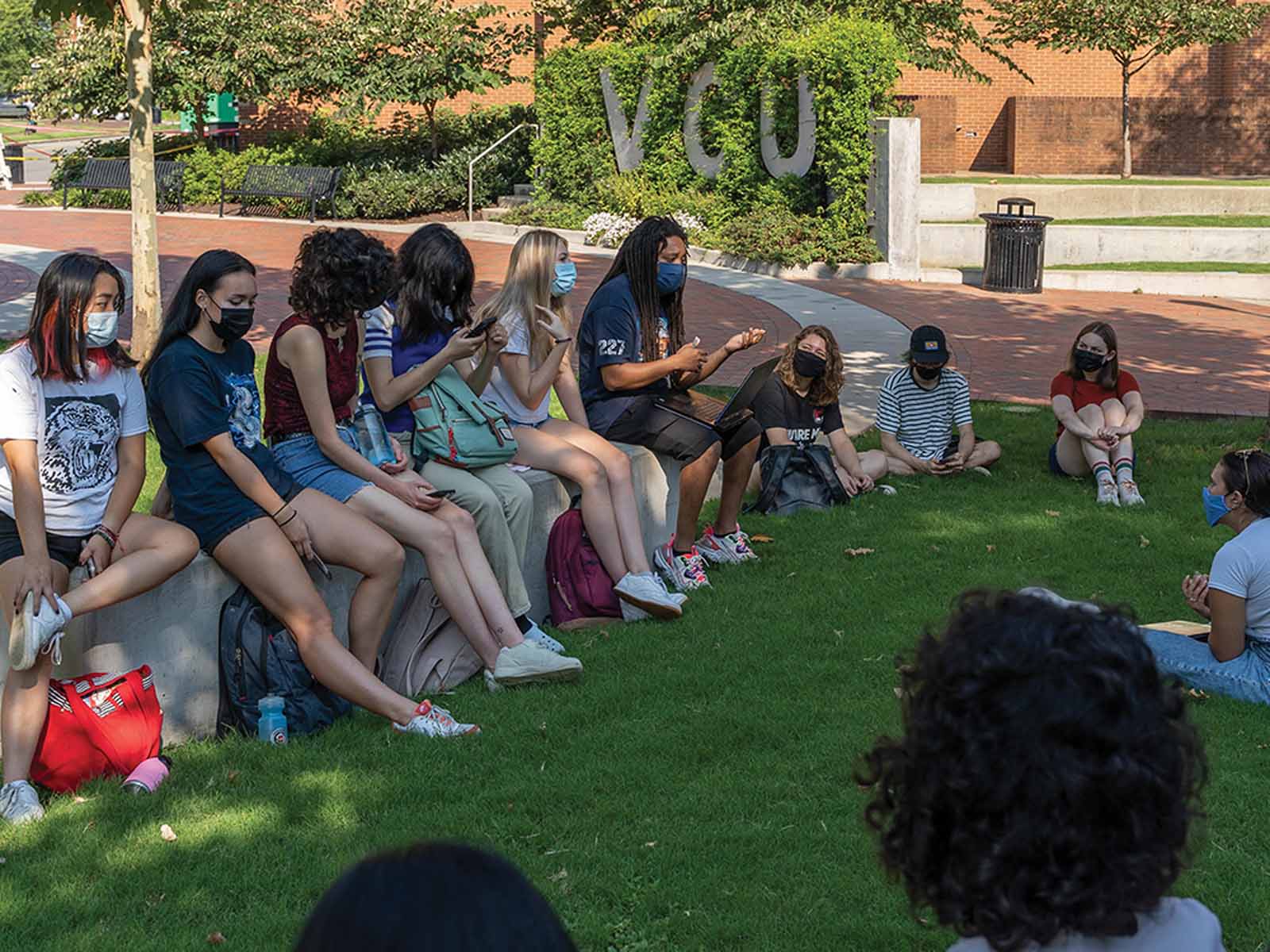Students sitting in a group outside in discussion