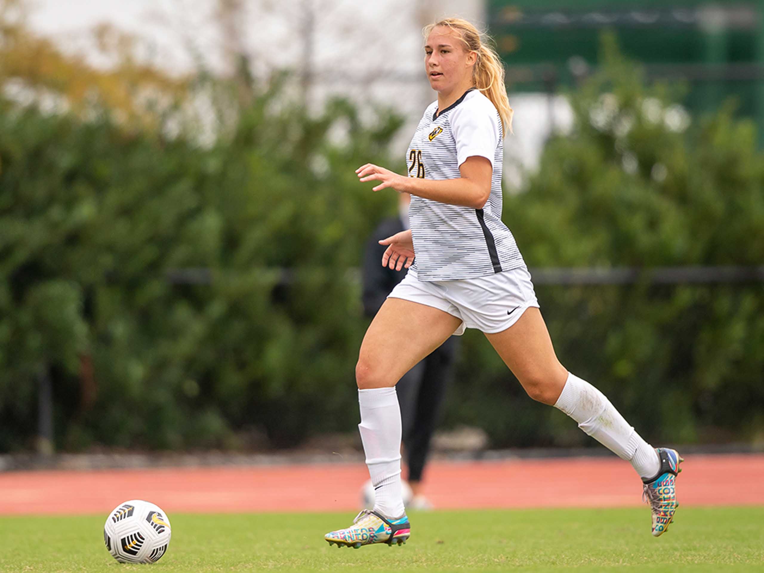 Lana Golob on a soccer field, dribbling the ball