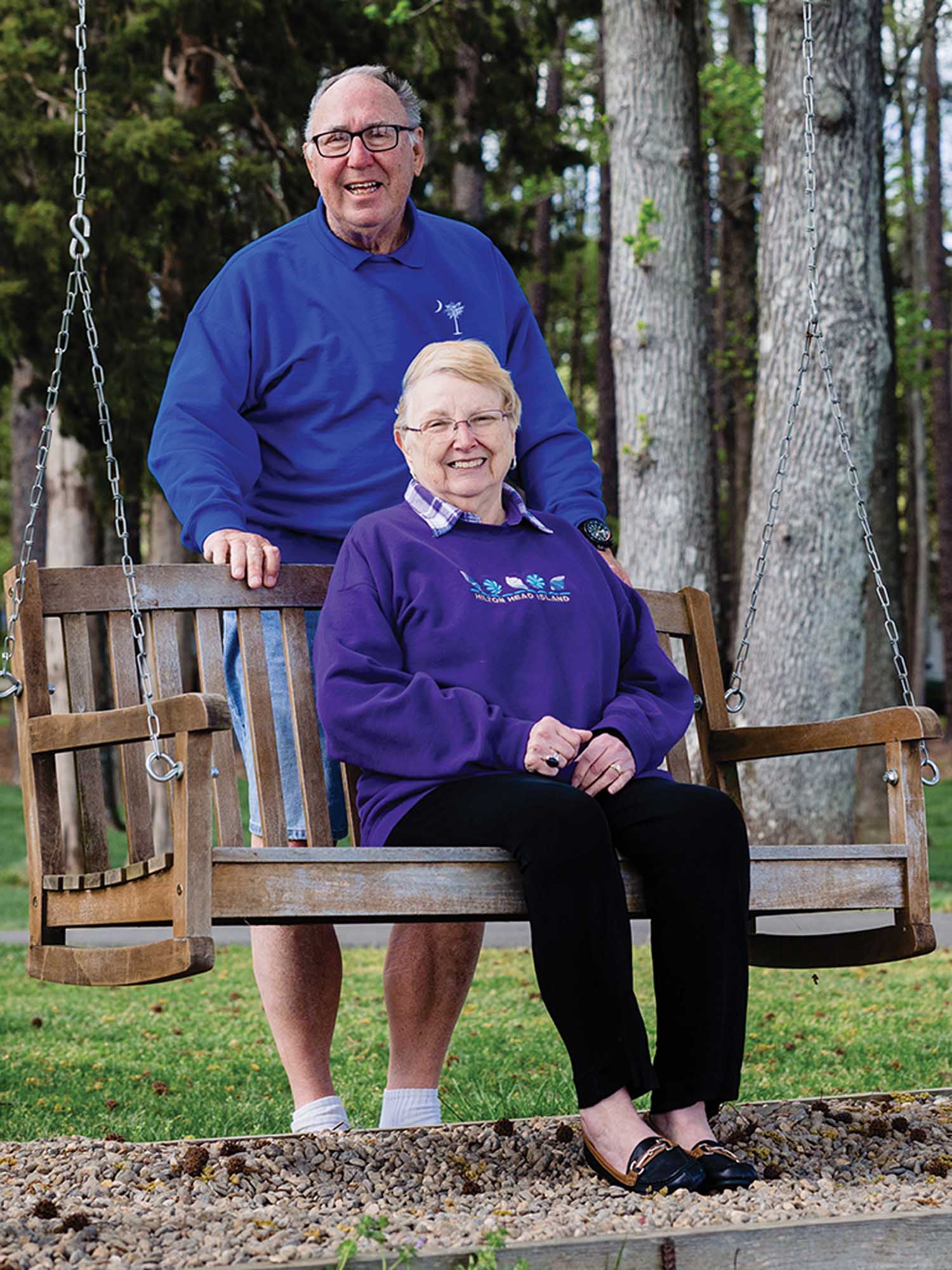 Norma Wood seated on a bench and Charles Wood standing behind her