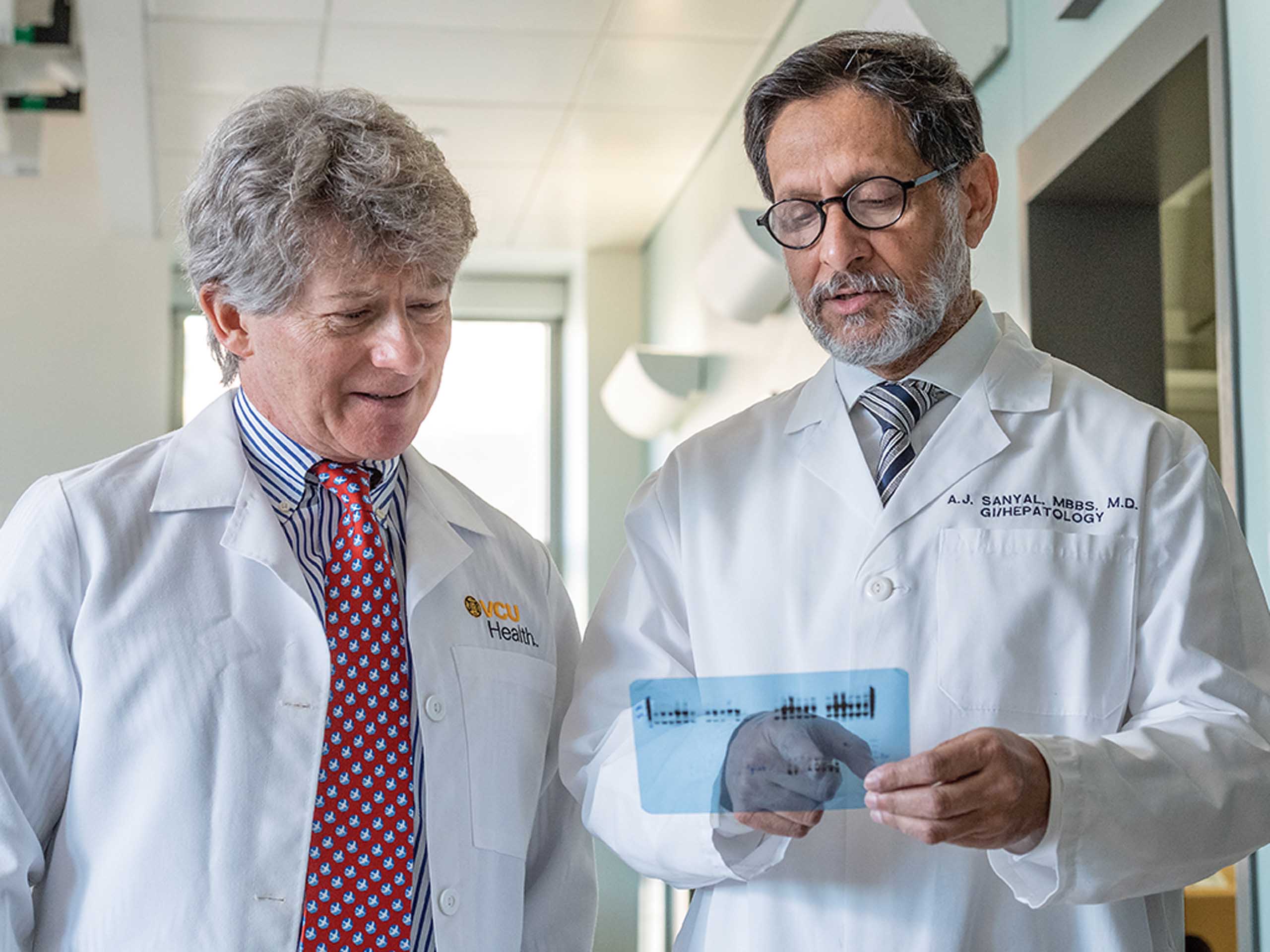 R. Todd Stravitz, M.D. and Arun Sanyal, M.D. reading a document